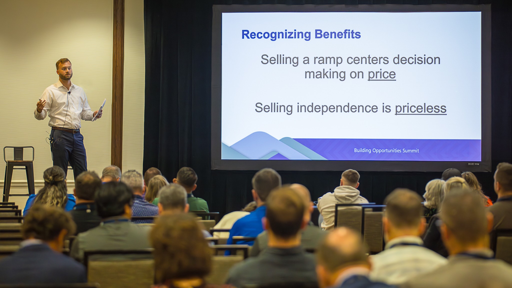 BJ Anderson delivering a keynote to a full room of DME and CRT sales professionals, with a slide reading Selling independence is priceless